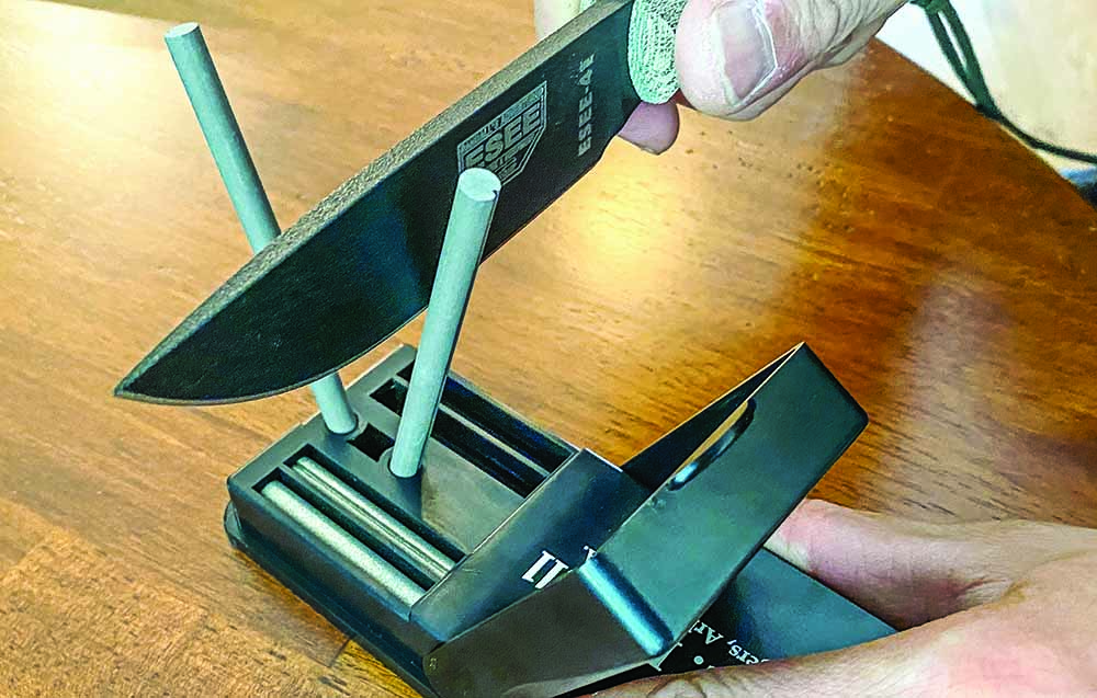 The Field Sharpener’s flip-up cover secures the rods when they are tucked inside the base. When open, the cover forms a guard to prevent the blade from coming down on your hand.