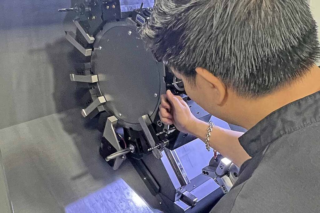 Princeton Wong checks the tooling on a CNC lathe.