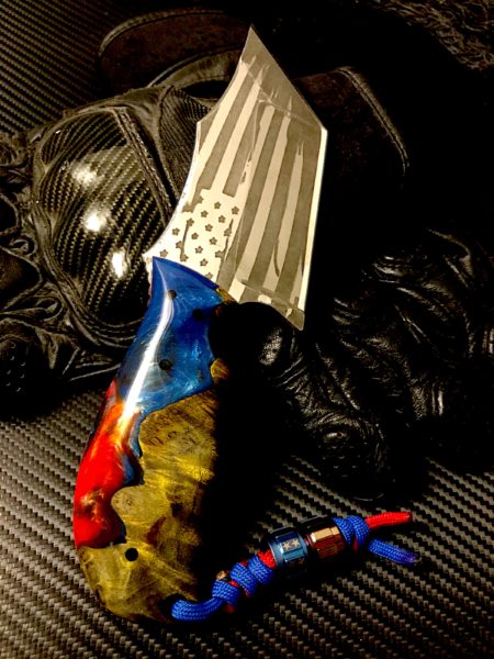 The Carnage by Black Widow Knifeworks & Tactical Gear sports patriotic resin with maple burl hybrid scales.