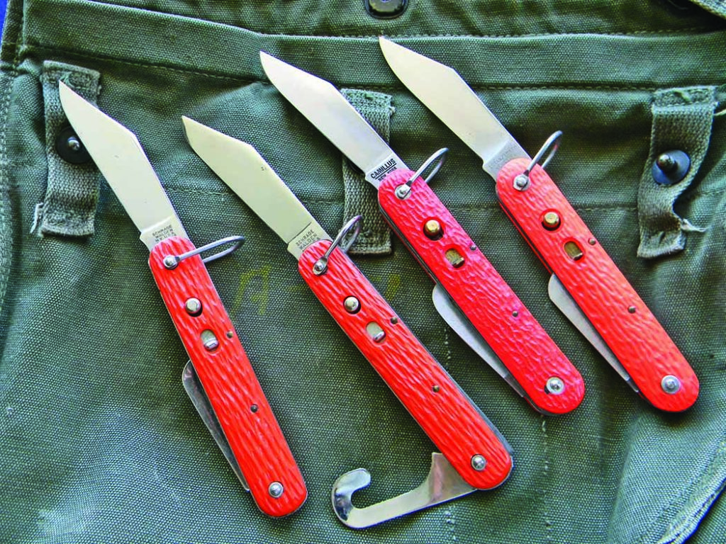 Military switchblades designated “MC1” included models in orange handles for heightened visibility. They were made by Schrade until 1960, when Camillus took over the contract. The knives have a master blade opened by a push button and a manual shroud cutter.