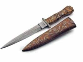 A small Bill Moran dagger features damascus, curly maple handle and silver wire inlay, and a matching sheath. Overall length: approximately 8 inches.