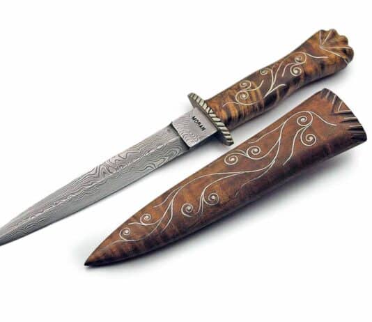 A small Bill Moran dagger features damascus, curly maple handle and silver wire inlay, and a matching sheath. Overall length: approximately 8 inches.