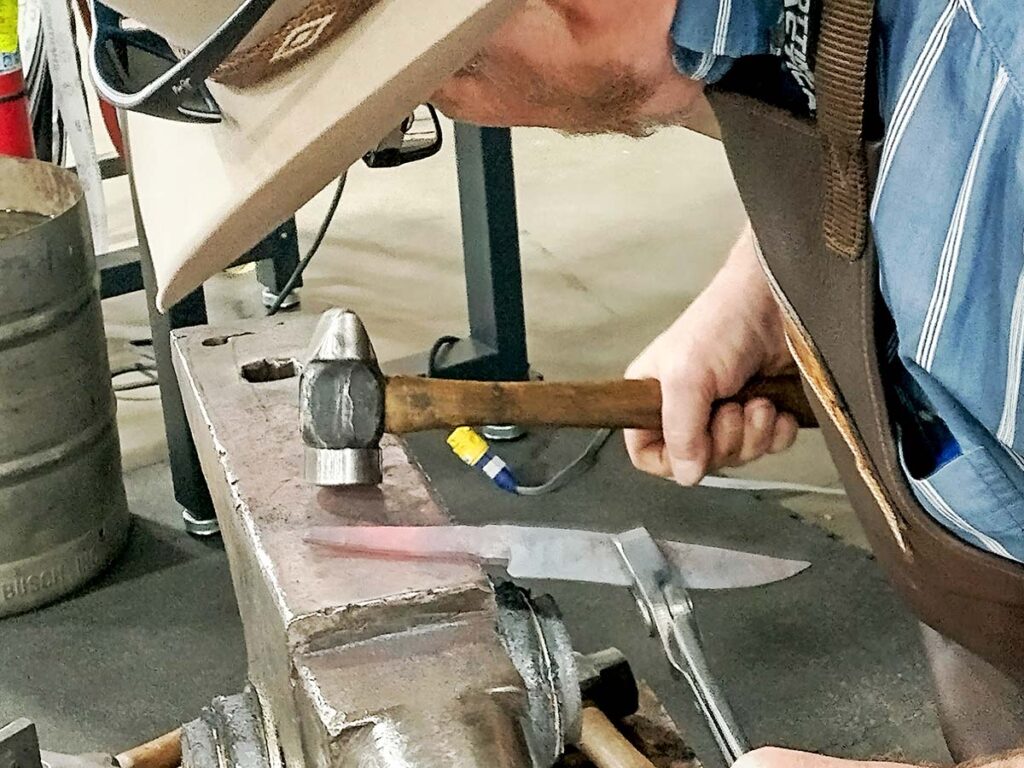 ABS Master Smith James Rodebaugh puts the finishing touches on a rough-forged hidden-tang knife at the indoor forge of Lonnie Jensen’s Mountain Shadow Forge.