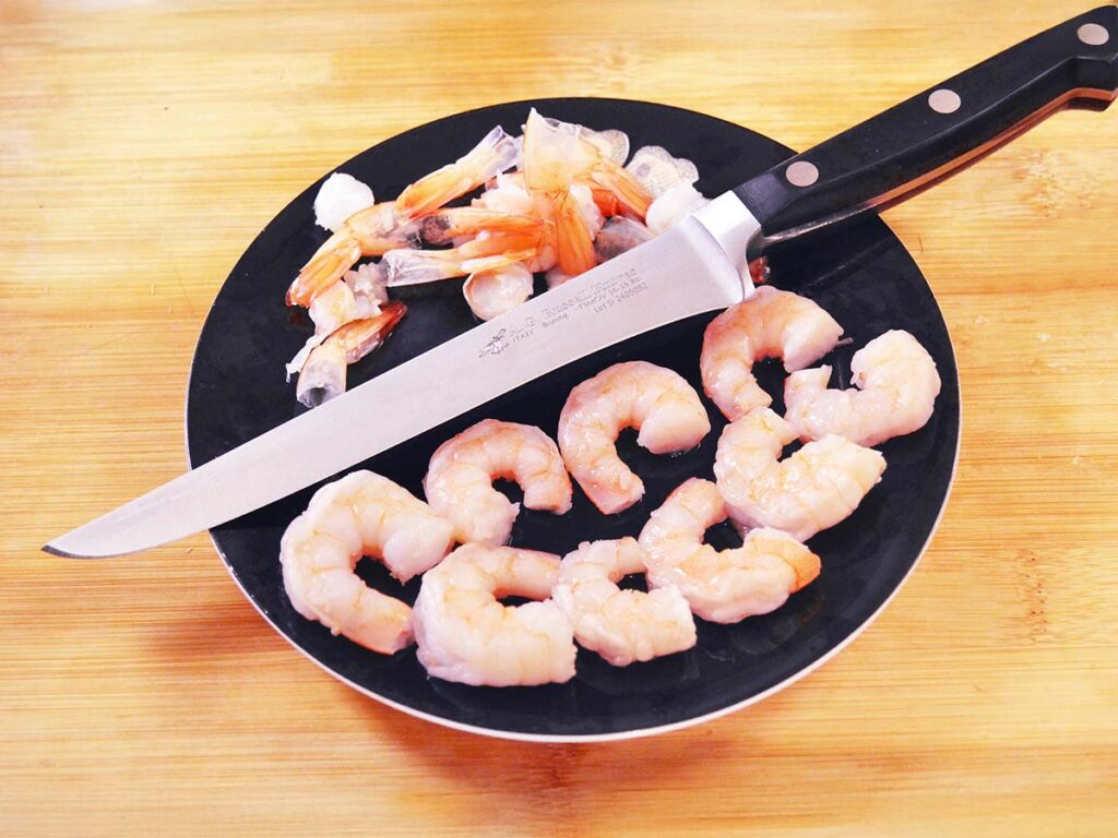 The A.G. Russell Boning Knife has a thin, sharp blade very much akin to a fish knife and can be used for other types of work around the kitchen. The author used the razor-sharp blade to cut off the tails of shrimp for a cocktail.