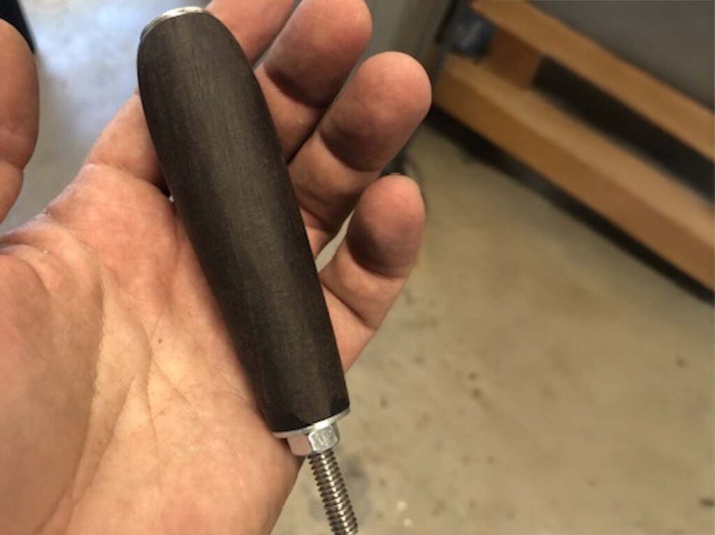 Both layout and shaping are made easier if the drilled handle is held between nuts on a long bolt or piece of threaded rod as a fixture.