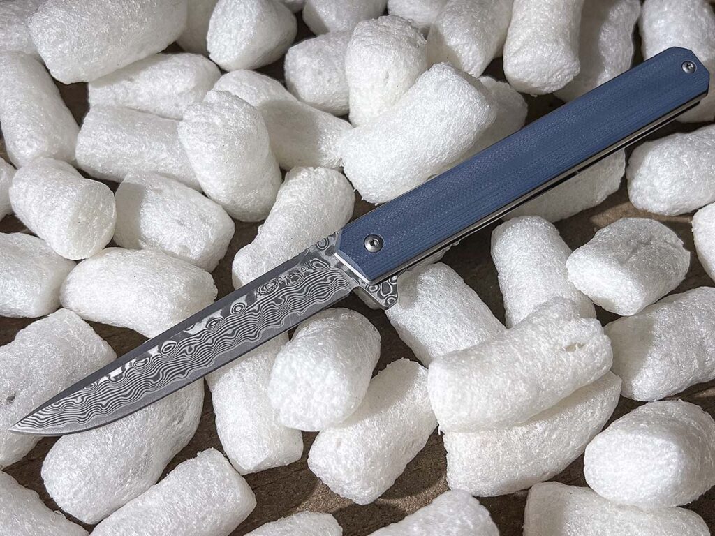 The A.G. Russell’s 3-inch drop point blade is a damascus san-mai hybrid of sorts, featuring a core of 9Cr13MoV stainless steel clad with stainless damascus on either side.