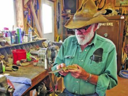 Ed Fowler cradles one of his trademark sheep-horn handle knives at his shop bench at his ranch in Riverton, Wyoming.