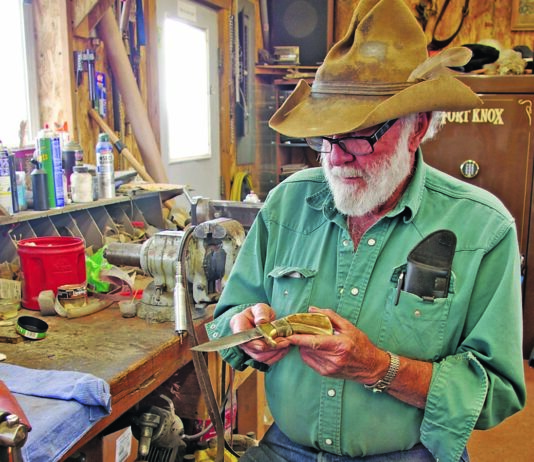Ed Fowler cradles one of his trademark sheep-horn handle knives at his shop bench at his ranch in Riverton, Wyoming.