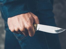 man hand holding knife on abstract background