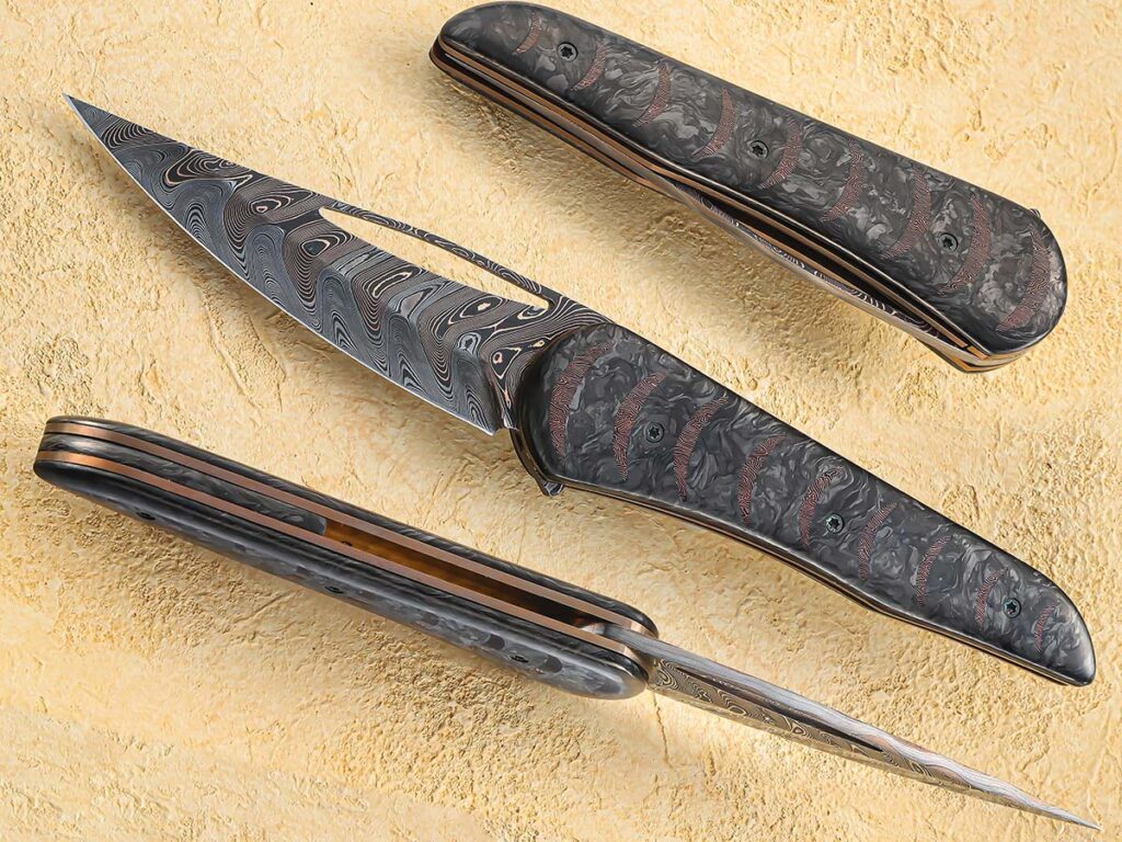 There’s something ominously attractive about what Alan Hollerbach achieves with this knife. Christened the Spectre—an homage to the nemesis organization of James Bond—the wasp-wasted flipper gets right to the point. Baker Forge TigerMai steel for the blade and Fatcarbon Dark Matter scales add to the knife’s dark good looks. (SharpByCoop image)