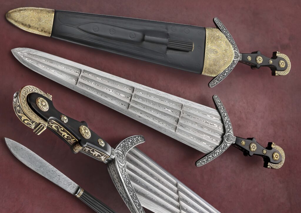 Vince Evans won Best of Show at last year’s Solvang Custom Knife Show for his sole-authorship Italian Cinquedea. The 16.5-inch blade with multiple fullers is damascus steel. The handle is ebony and the guard is an engraved combo of steel, brass and bronze. Overall length: 22.5 inches. The sheath is leather over wood and bronze and also houses a small fixed blade. (SharpByCoop knife image)
