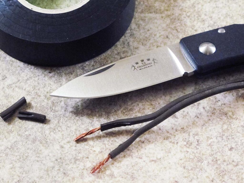 The author used the Fallkniven U2Vi Virgo to score two tails of cord vertically and peel off the coating, leaving tails of bare wire ready to splice. The blade was plenty sharp and did the job well.