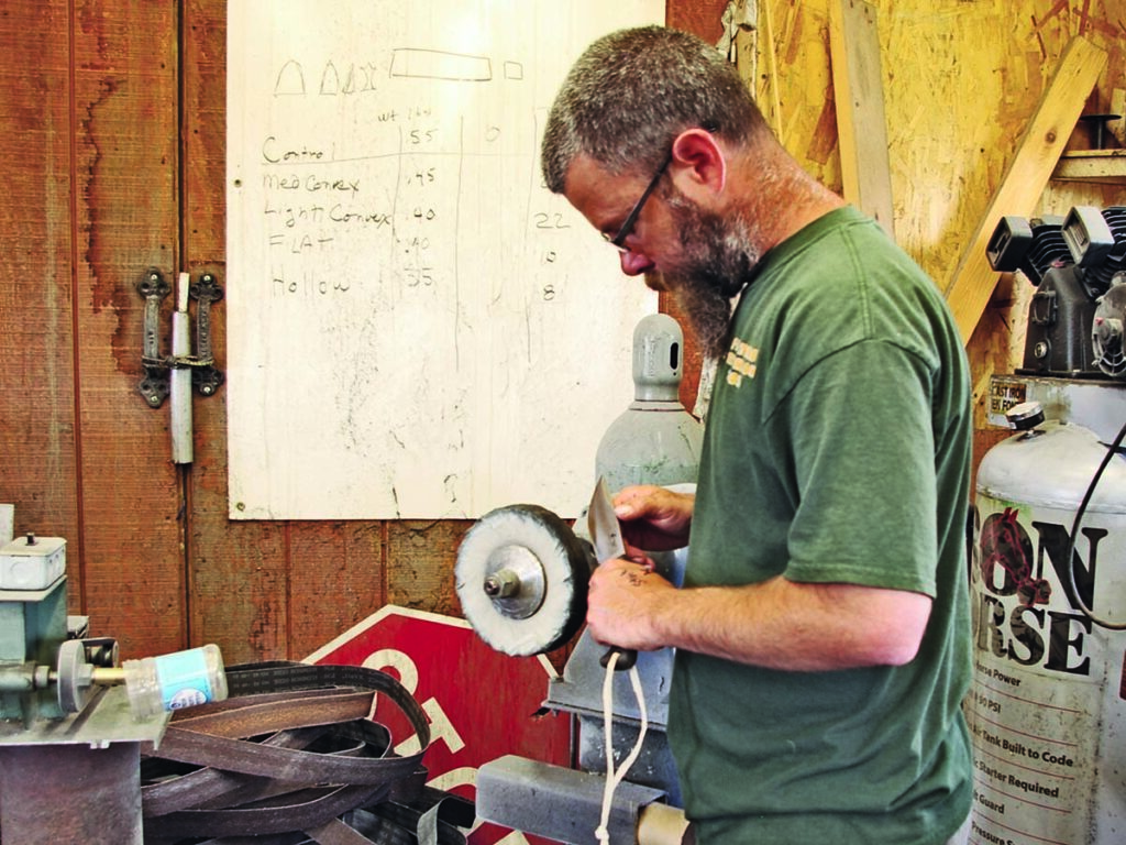 As Ed Fowler noted, when buffing or grinding a hardened blade, the hand can communicate the temperature. Chris Amos buffs a blade in Ed’s shop in this file photo. (Fowler image)
