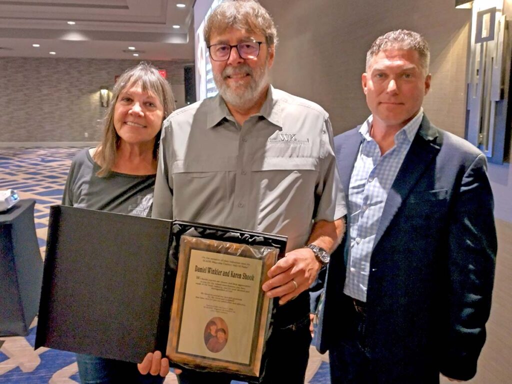 From left, Karen Shook and Daniel Winkler accept their plaque after Kevin Holland (right) delivered their induction speech.