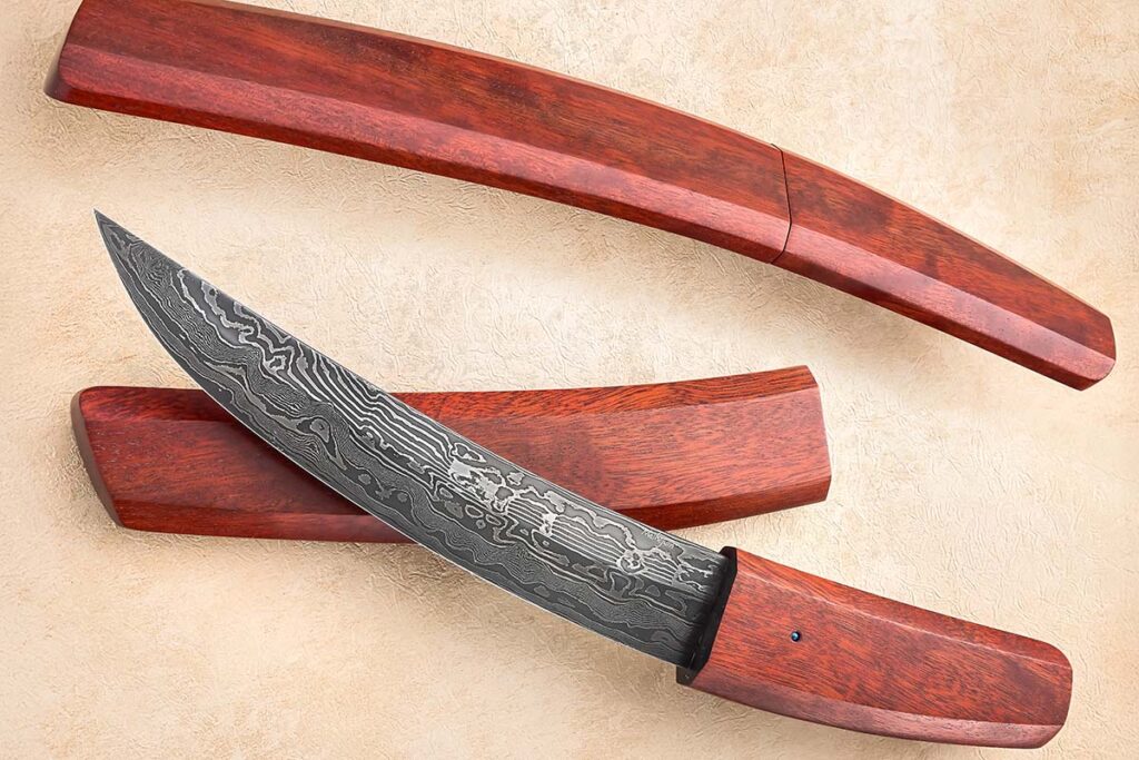 ABS journeyman smith Mardi Meshejian gives the Japanese look a damascus and smooth polished wood treatment with his curvaceous fixed blade and saya (scabbard). Note the seamless fit of knife and saya.