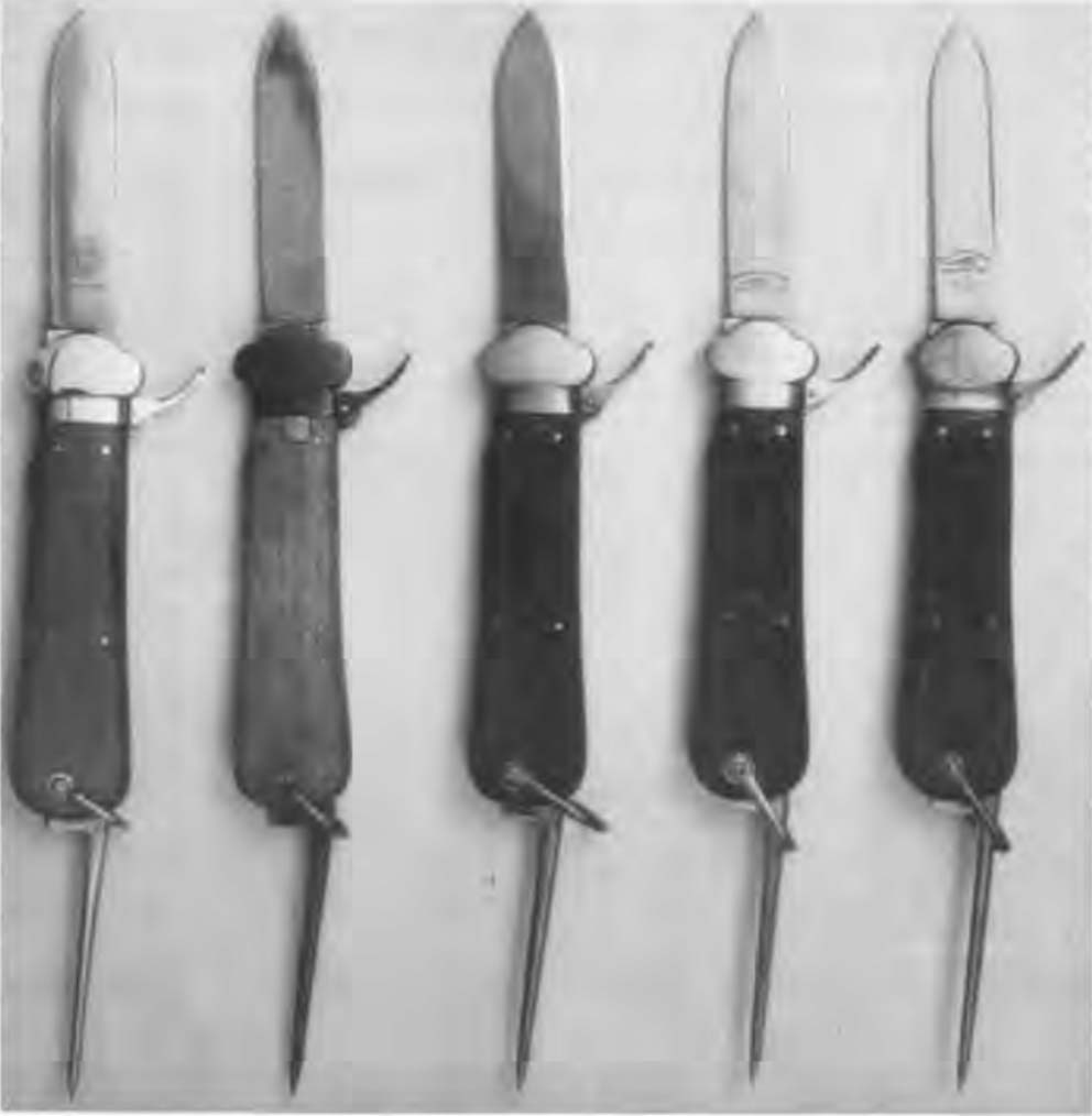 Five World War II-era OSS gravity knives, from left: a trial piece with George Ibberson blade markings; one with a variation of an Ibberson marking; unmarked issue specimen; German-issue take-down model; and a German-issue non-take-down model.