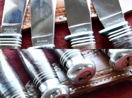 The four fixed-blade hunting knives exhibit identical blade shapes, fiber spacer patterns, aluminum pommels, and stacked-leather handle construction, but each has a different blade tang stamp. From left to right, the blades are stamped “Jean Case,” “Belnap,” “Kinfolks,” and “Hollinger.”