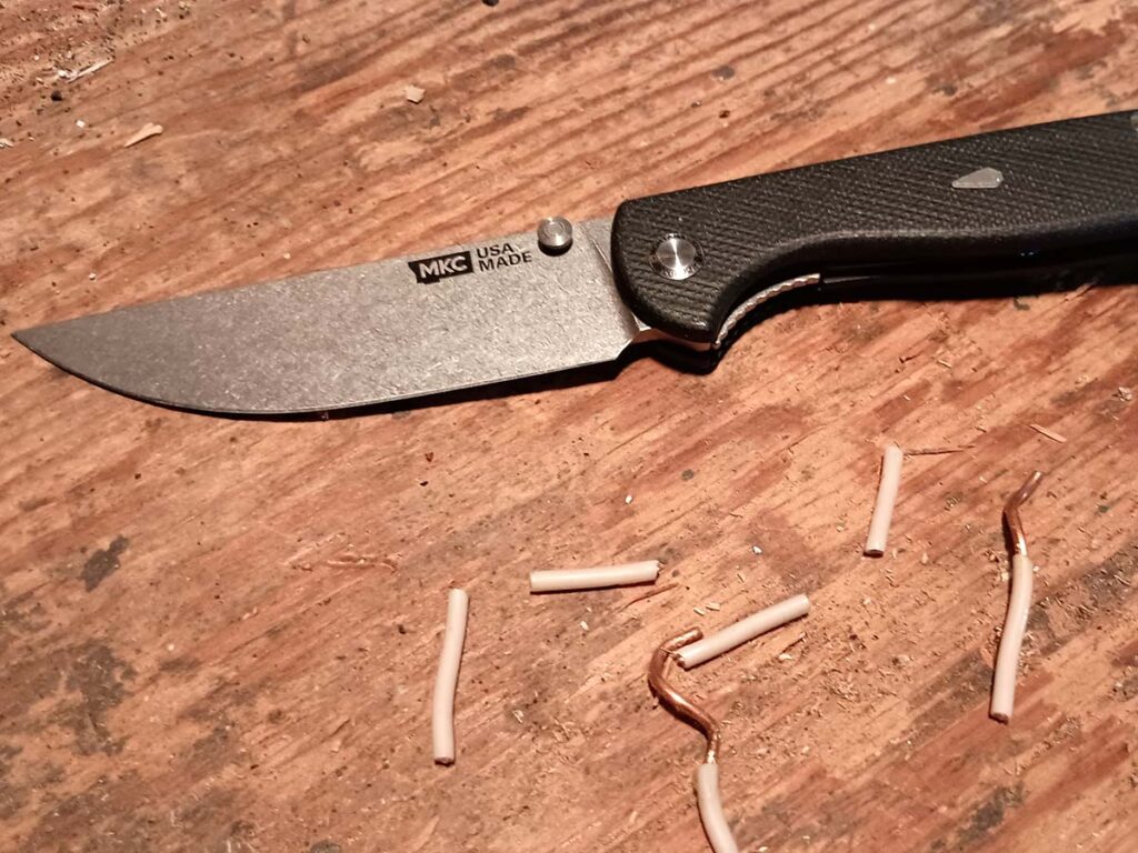 The knife made quick work of copper wiring, dividing it with the help of a rubber mallet. The edge was undamaged in clipping the 6-gauge wire and remained sharp enough to easily shear paper afterward.