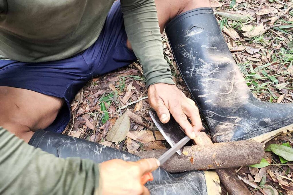 tribesman from Colombia, uses a common triangular file on the axes and machetes