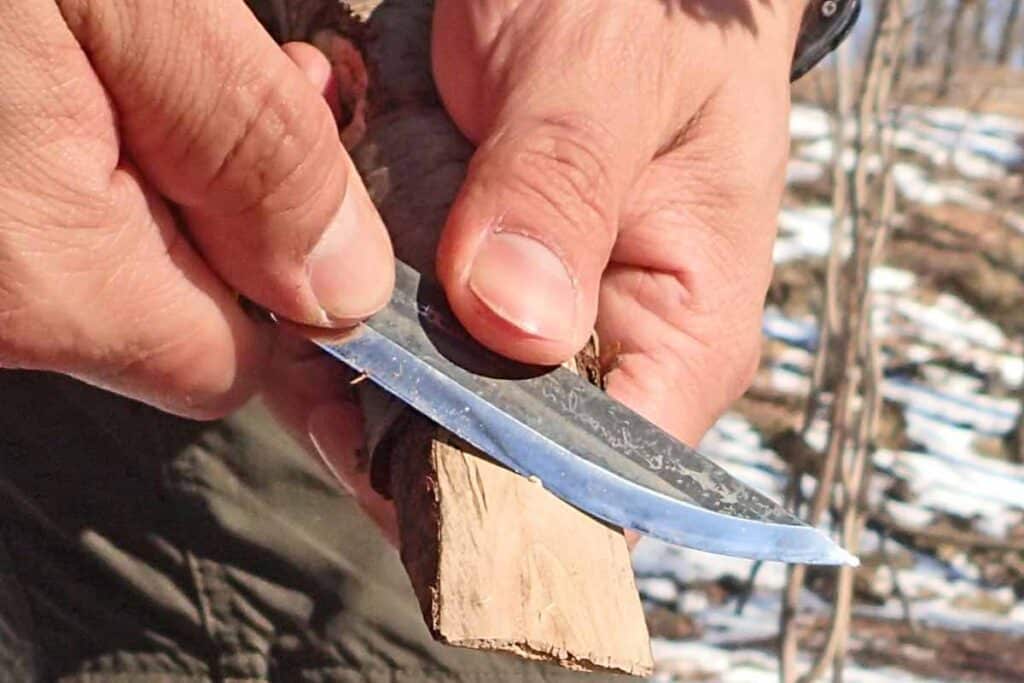 Fine-tuning a wooden wedge using the chest-lever grip with the Marttiini Arctic Bush Knife.