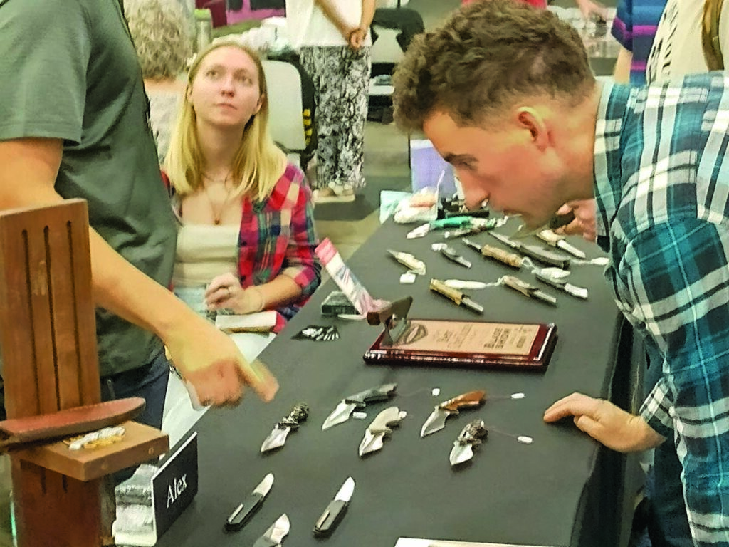 It’s easy to get mesmerized by knives at the BLADE Show, here at the table of Alex Hossom (left).