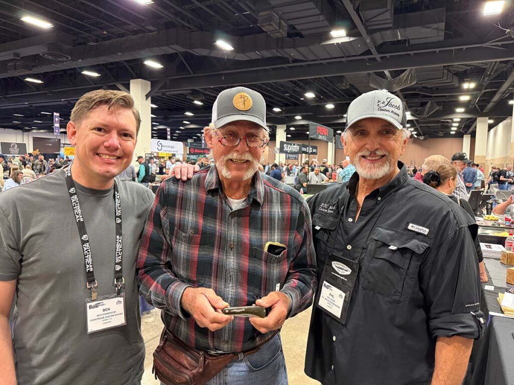 Ben Champagne (left) and Phil Jacob (right) present Rusty Preston (center) with his special surprise knife at BLADE Show Texas 2025 (page 56).