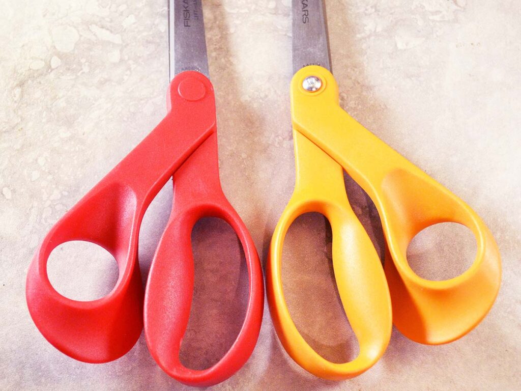 Fiskars is one of the few major companies that manufactures scissors specifically for lefthanders, and is known for such radically asymmetrical designs as these two. The red pair is for lefties.