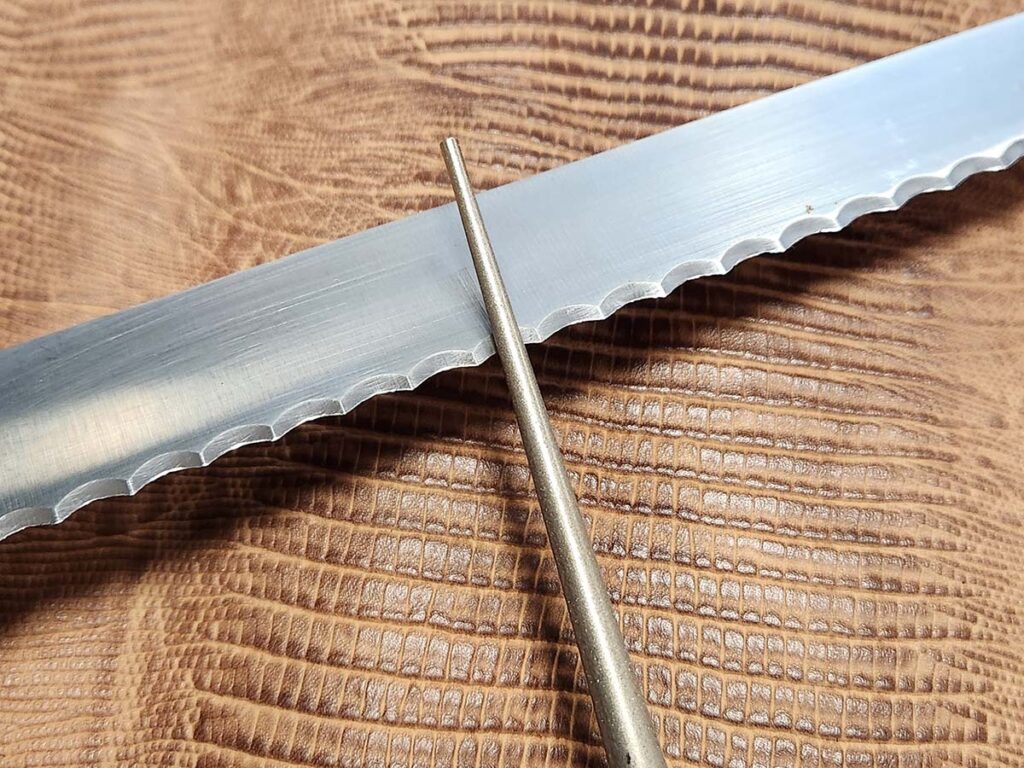 Sometimes when sharpening a serration with a broad diameter, the author follows the secondary bevel across the edge instead of pushing the sharpener into the blade.