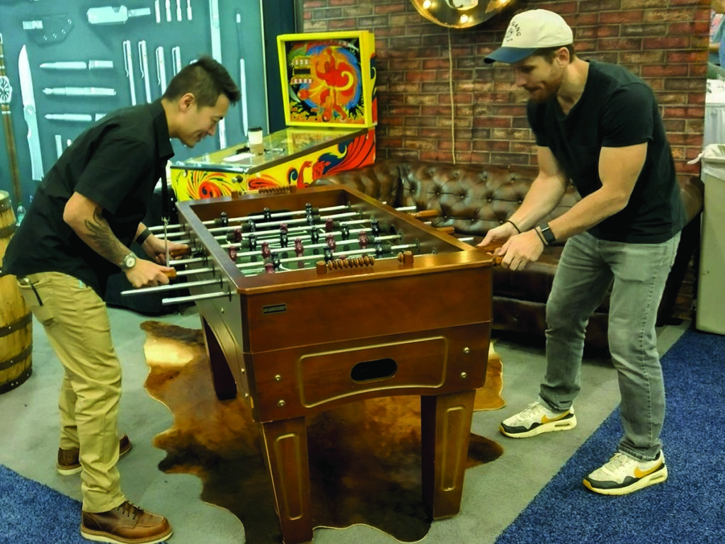 Knife fans try their hand at foosball at the Big Idea Design booth.