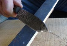 This is the strop on the 1500 grit sandpaper side of the strop stick. The angle is maintained while the smith slides the edge back and forth several times to break the burr. The smith travels the length of the stick and the length of the blade’s edge in a continuous motion.