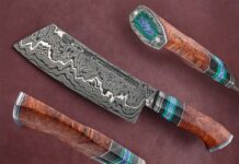 Robert Wayman quips that he packed a lot into his 14-inch pattern damascus cleaver, mainly in the handle. The grip features a damascus collar, stainless steel and G-10 spacers, cross-cut carbon fiber, green malachite and blue coral accents, stabilized amboyna burl, and a damascus butt cap with stainless mounting pins inset with blue coral, framed with green malachite. (SharpByCoop image)
