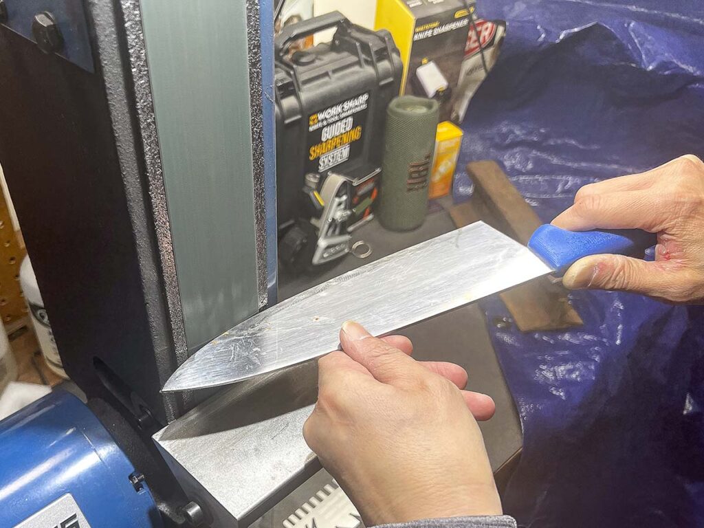Image 2: First step is to grind the edge down past the deepest ding to remove them all. This reduces the height of the blade somewhat but not to the point where it is detrimental.