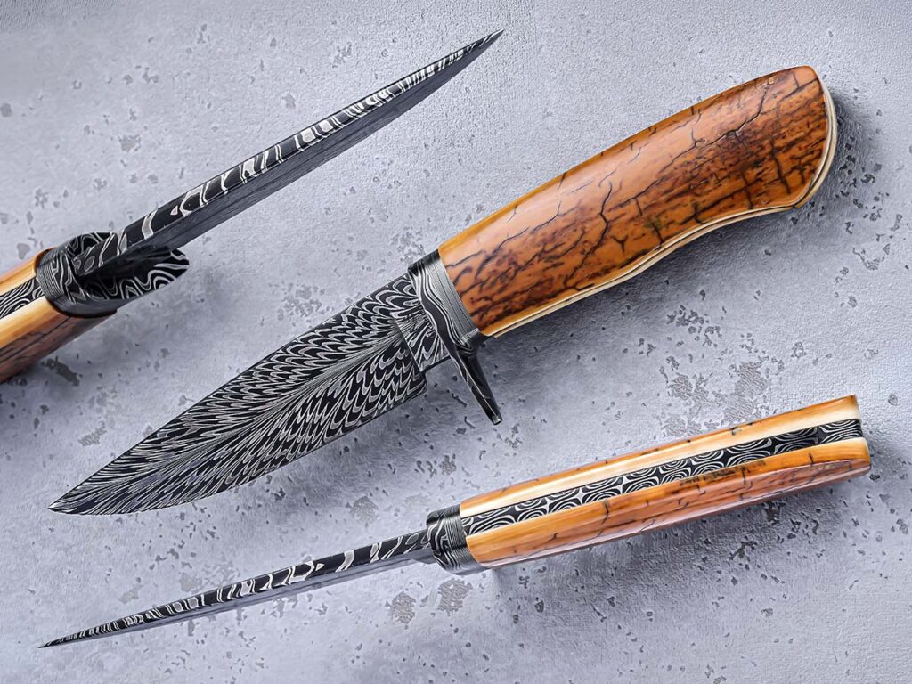 Splitting the billet down the center to maintain symmetry is among the trickiest aspects of feather damascus to Steve Randall. He nails it on his frame-handle hunter, with the axis of the pattern fountaining from the mastodon scales in a balanced and spectacular fashion. (SharpByCoop image)