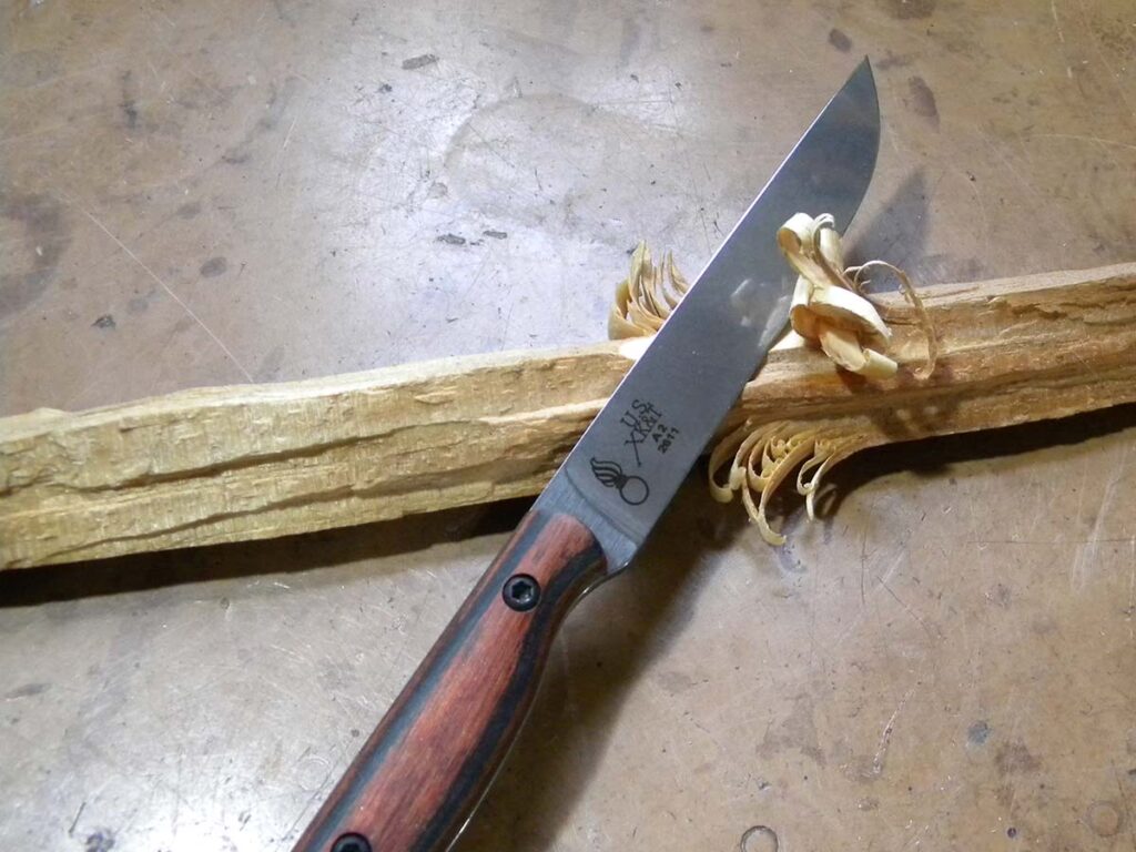 Since the handle is as narrow as the blade, the author had to adjust his grip a few times when whittling the firestick. The deeper he cut, the more it wanted to roll in his hand. So he made the curlicues thin and kept on whittling. As he noted, “It’s a handy whittler in any case.”