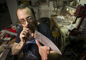 Custom knife maker Adam Balkovic of Biltsharp Manufacturing Co. checks the edge and his handmade knives in his workshop in Philadelphia. ( ALEJANDRO A. ALVAREZ / STAFF PHOTOGRAPHER )