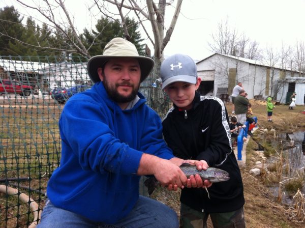 David McConnell of North Woods Forge helped his son Parker catch a trout at the National Trout Festival in Kalkaska, Michigan.